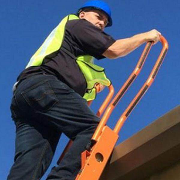 Man wearing hard hat at the top of an orange ladder with grab handles.