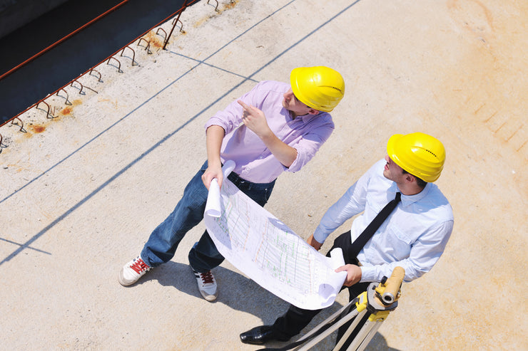 A construction team reviews plans for construction projects that need permanent fall protection