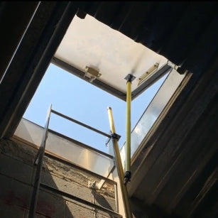 NextGen roof hatch safety guardrail system surrounding an open access hatch on a roof.