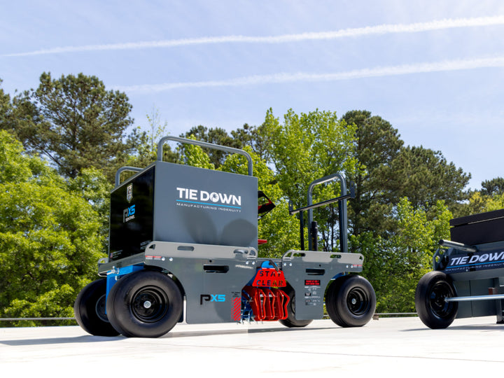 Portable fall protection cart system with an integrated tie-off point parked on flat roof
