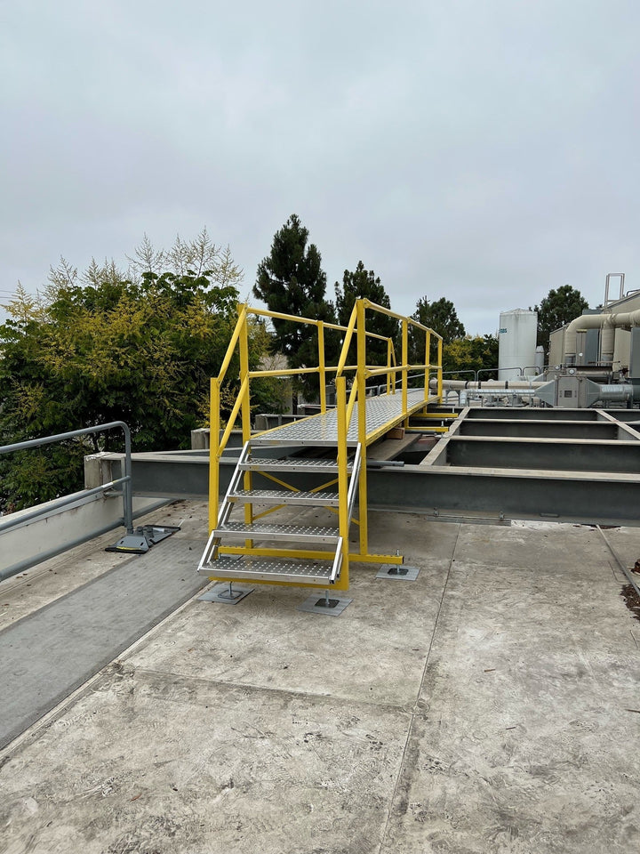 The image shows an aluminum railing for stairs on an industrial rooftop.
