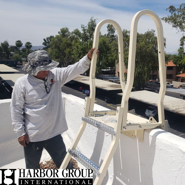 Worker installing a safety ladder with logo overlay of Harbor Group International