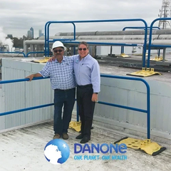 Two men standing on a commercial rooftop with Danone logo overlay