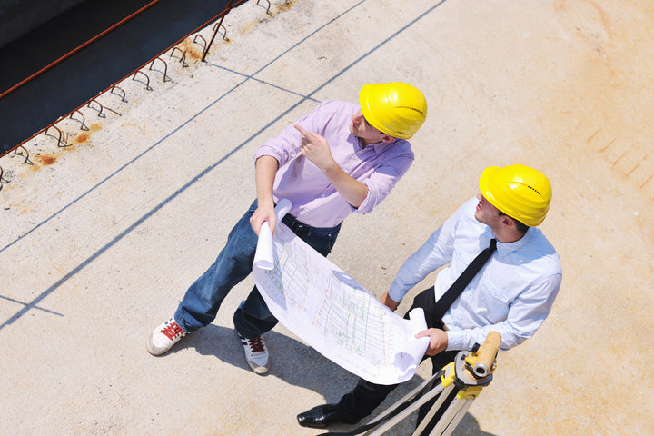 A construction team reviews plans for construction projects that need permanent fall protection
