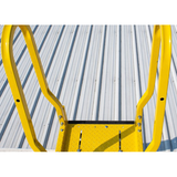 Yellow metal ladder against a corrugated metal wall
