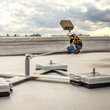 Person on a roof using equipment, with a cloudy sky in the background