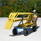 Person operating a yellow roof cart with a load of safety railing outdoors