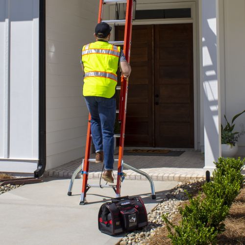 Man climbing extension ladder with Safety-Legs